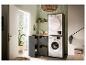 Buanderie avec lave-linge, sèche-linge et solutions de rangement le long d'un mur carrelé vert.