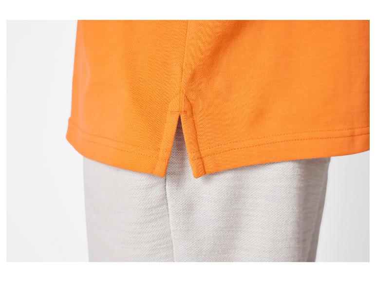 Polo orange avec pantalon gris.