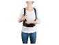 Une femme portant un t-shirt blanc et un jean bleu porte un soutien dorsal noir.