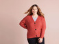 Une femme porte un pull en maille rouge.