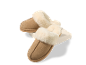 Paire de pantoufles confortables en daim beige avec doublure en fausse fourrure crème, posées sur un bloc blanc.
