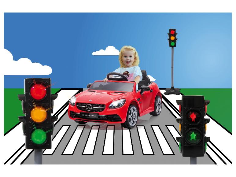 Une enfant conduit une Mercedes SLC 300 Final Edition rouge sur un passage piéton.