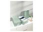 Trois boîtes de rangement vert menthe pour vêtements sur une armoire blanche.