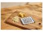 Fromage râpé et une râpe en métal sur une planche à découper en bois.