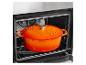 Cocotte en fonte orange à l'intérieur d'un four