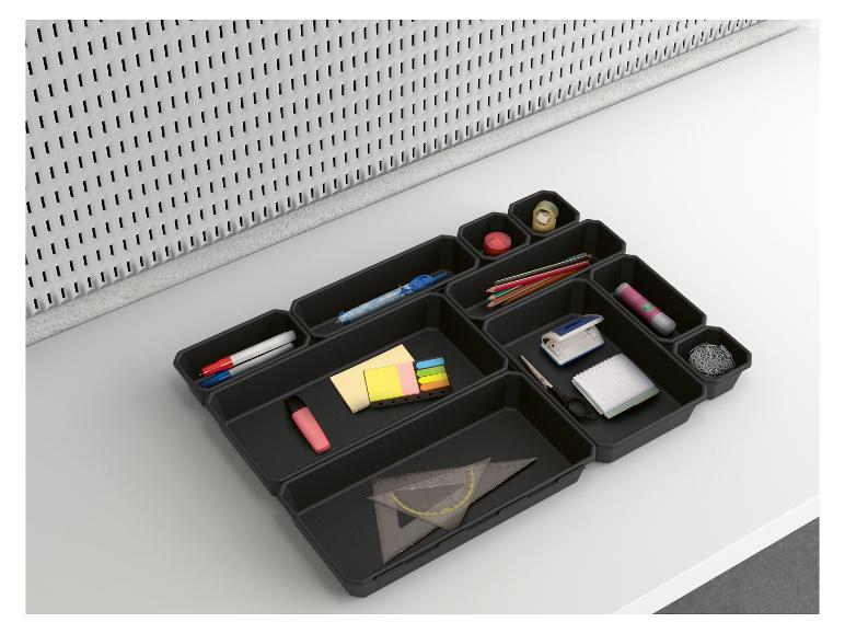 Organisateur de bureau noir avec des fournitures de bureau comme des crayons, des trombones et des blocs-notes.