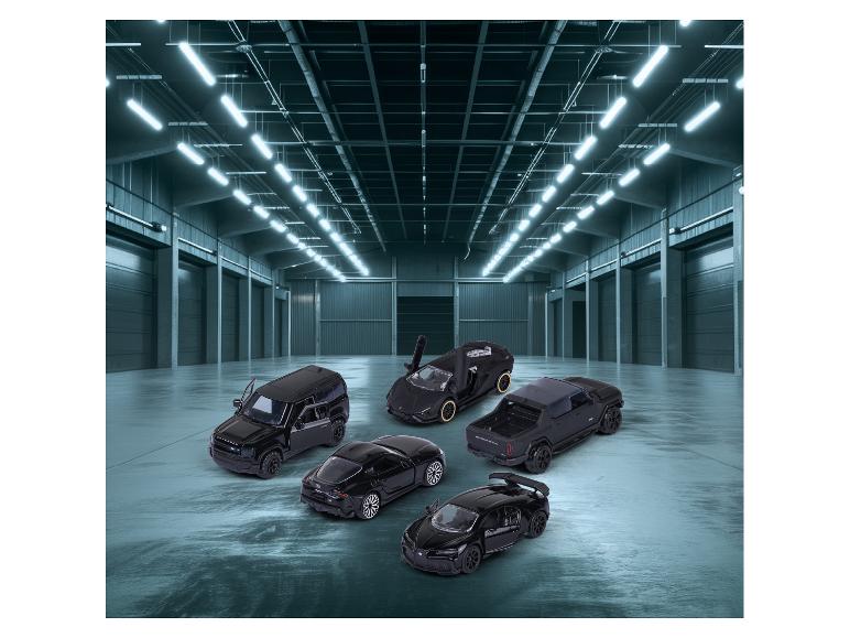 Voitures jouets noires, dont un Land Rover Defender et une Bugatti Chiron, dans un entrepôt.