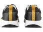 Des baskets noires avec des accents jaunes.