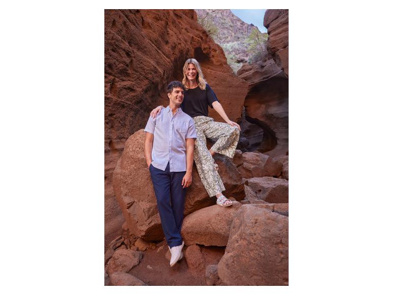 Homme en chemise à manches courtes et pantalon, femme en t-shirt et pantalon à motifs.