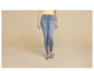 Une femme porte un jean skinny et des sandales à nœud rayées.