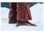 Bottes d'hiver noires sur la neige, pantalon de ski rouge.