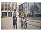 Deux personnes font du vélo électrique en ville.