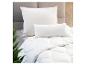 Une couette blanche avec deux oreillers sur un lit.