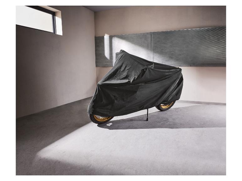 Moto recouverte d'une housse de protection noire dans un garage.