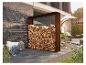 Range-bûches extérieur avec bois empilé, à côté d'un mur de briques et de mobilier de patio.