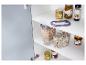 Deux contenants de stockage en verre avec des flocons d'avoine et du riz, suspendus dans une armoire de cuisine.