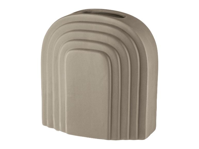 Un vase en céramique gris avec un design incurvé en forme d'arc.
