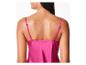 Une femme porte un haut en satin rose.