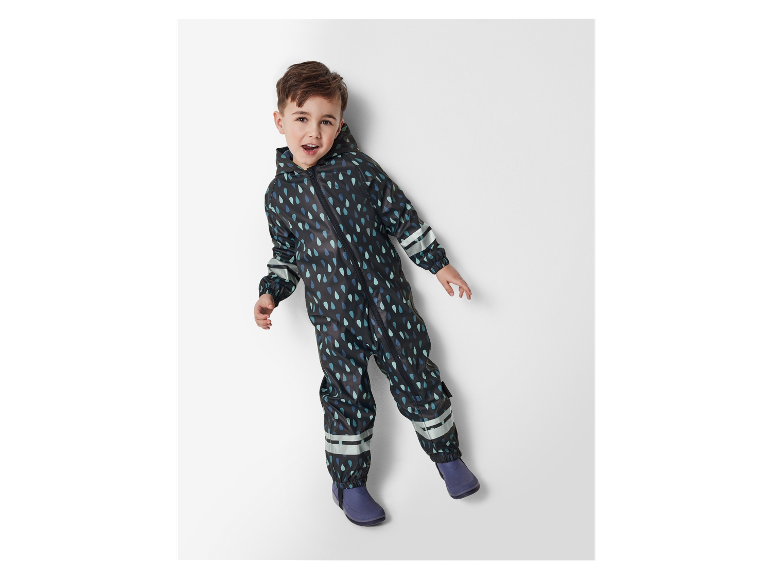 Petit garçon portant une combinaison imperméable à motif gouttes.