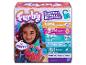 Un jouet Furby rose que tient un enfant. La boîte présente différentes options de jeu.
