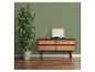 Mur vert avec une grande plante en pot et un meuble en bois avec un tourne-disque.