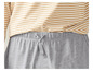 Un short gris avec un cordon, porté sur un haut rayé.