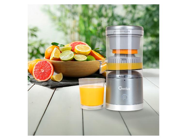 Presse-agrumes Genius avec oranges, pamplemousses, citrons et citrons verts sur une table en bois.