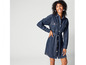 Une femme porte une robe en jean bleu avec une ceinture.