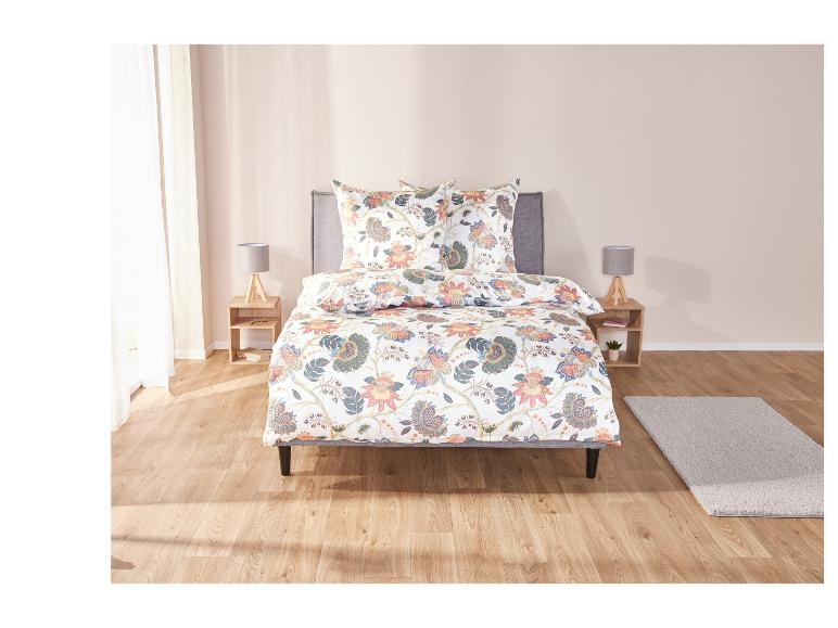 Un lit avec une couette à motifs floraux.