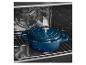 Cocotte en fonte bleue dans un four sur une grille.