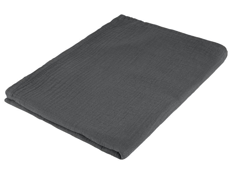 Une couverture en coton gris foncé pliée sur un fond blanc.