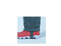 Jambes de pantalon vertes avec des bottes rouges.