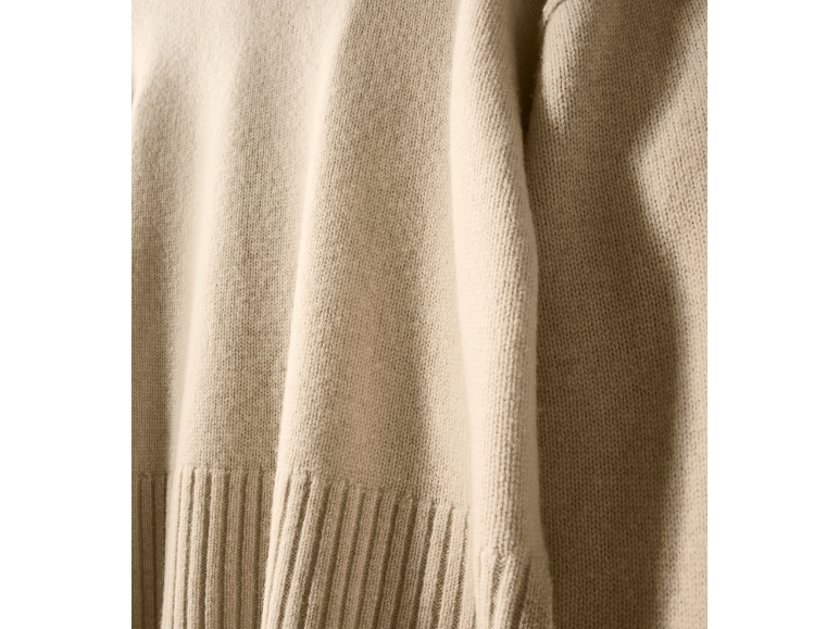 Gros plan d'un pull en maille beige doux avec ourlet côtelé
