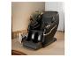 Fauteuil de massage noir avec des détails dorés dans une pièce avec tapis.