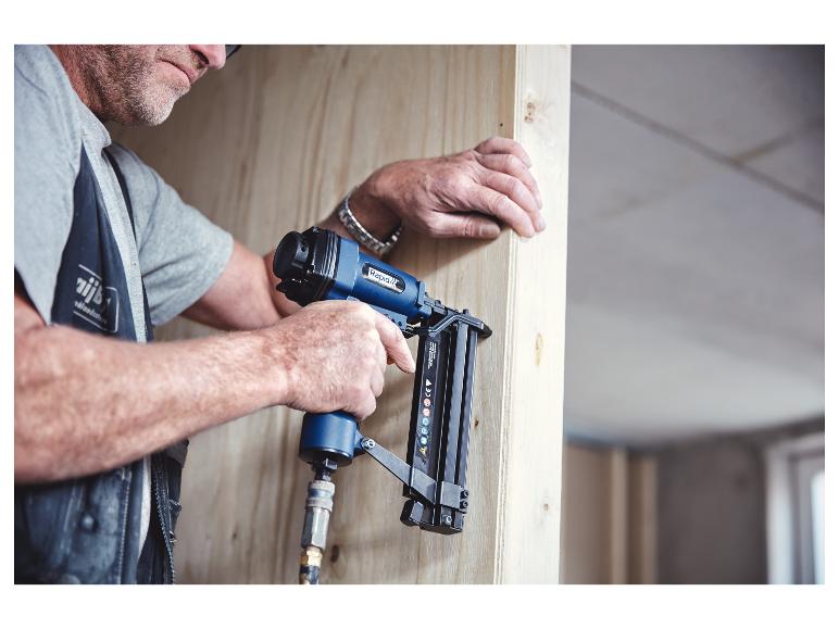 Homme utilisant une agrafeuse/cloueuse pneumatique pour fixer des panneaux de bois.