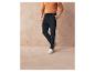 Un homme portant un pantalon cargo bleu foncé et des baskets blanches.