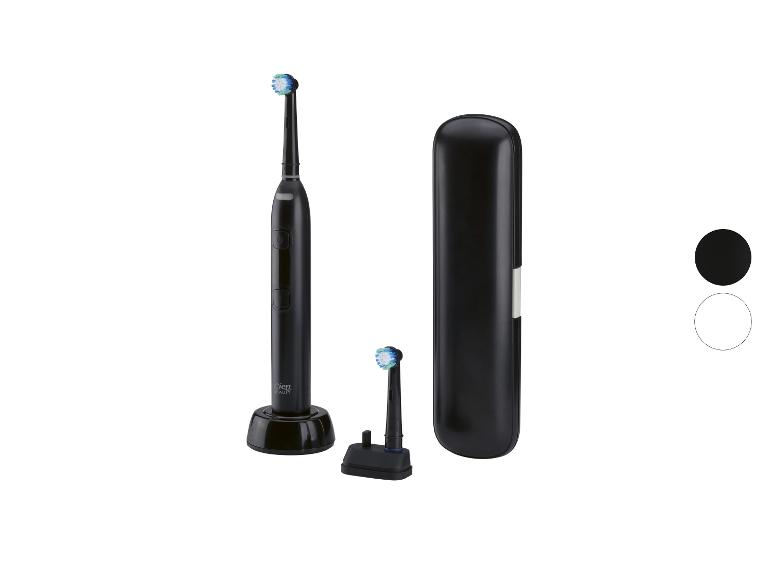 Brosse à dents électrique noire avec têtes de rechange et étui de voyage.
