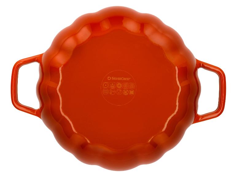 Plat de cuisson orange avec un bord ondulé et deux poignées.