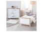 Commode et lit blancs et en bois dans une chambre d'enfant.