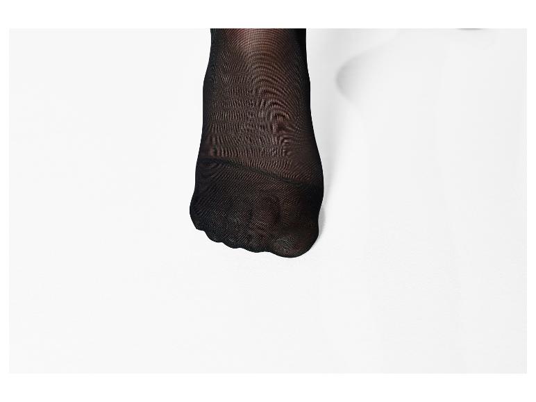 Pied avec collants noirs sur fond blanc.