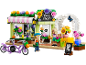 Magasin de fleurs jouet avec deux figurines, vélos et arrangements floraux.