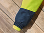 La manche d'une veste en bleu foncé avec une doublure intérieure verte.