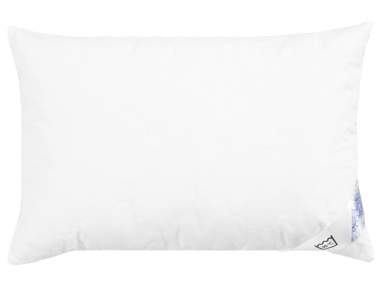 Un oreiller blanc avec un motif matelassé.
