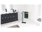 Salle de bain avec porte-serviettes en métal noir et accessoires vert foncé.