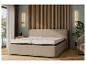 Un lit beige avec un matelas et une tête de lit dans une chambre moderne.