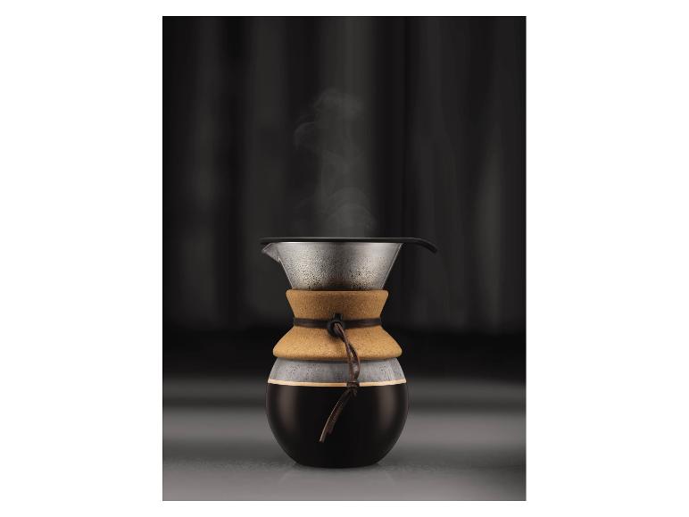 Cafetière en verre avec bande de liège et café fumant.