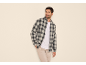 Homme en chemise à carreaux, t-shirt blanc et pantalon beige