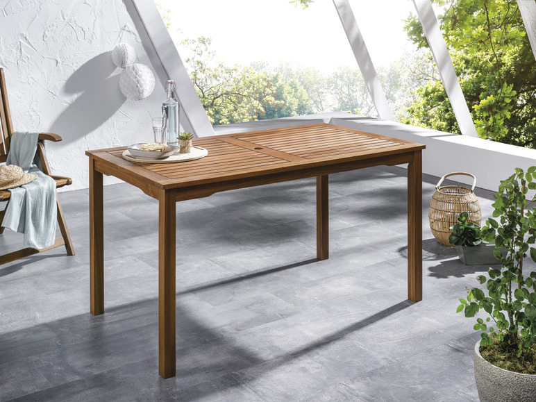 Une table en bois pour l'extérieur avec une chaise et des plantes.