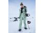 Une femme avec une veste et un pantalon de ski verts tenant un snowboard dans la neige.