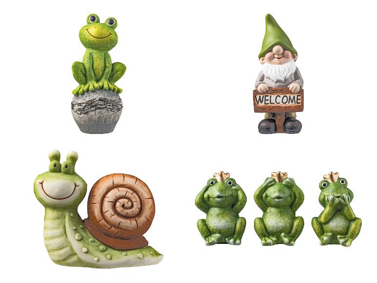 Figurines de jardin avec des grenouilles, un escargot et un gnome avec une pancarte 'Bienvenue'.